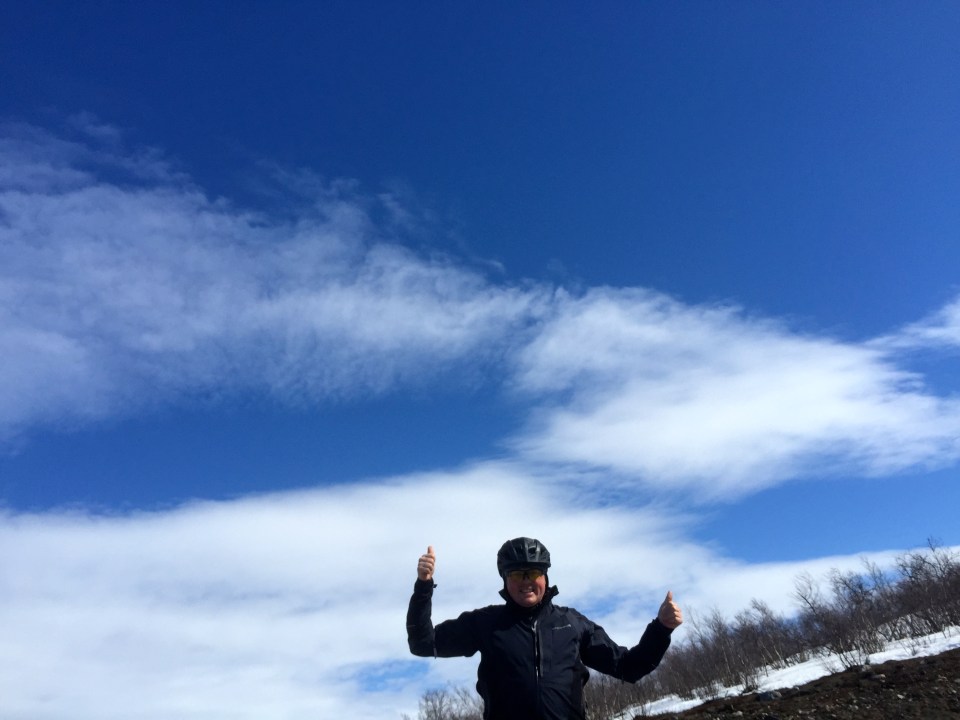 Double thumbs up under blue skies